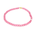 Pink agate bead necklace with a clear accent bead and golden clasp on a white background - Pink