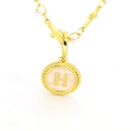 Vue macro du pendentif lettre H dorée avec émail rose, perles et breloque croix - Lettre H