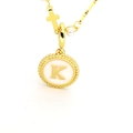 Détail macro du pendentif ovale doré avec lettre K, breloque croix et perle blanche - Lettre K