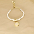Detailed view of adjustable pearl bracelet featuring a gold round letter G pendant charm - Letter G