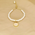 Adjustable pearl bracelet with a pink gold-edged round pendant featuring the letter I - Letter I