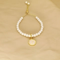 Detail of pearl bracelet featuring golden J letter pendant and adjustable pull clasp - Letter J