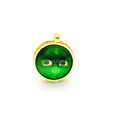 Macro shot of ethnic style round golden pendant with green eye pattern inlay and ornate frame - Green Eye Spiral (A5)