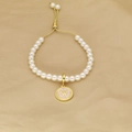 Detail of pearl bracelet with pink enamel letter W pendant and adjustable gold slider - Letter W