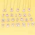 Puffy balloon style alphabet pendants with cubic zirconia inlay on a yellow background - Letter A / White Gold