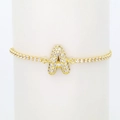 Close-up of golden tennis bracelet with pavé zircon bubble letter A on white stand - Letter A