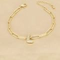 Detail of 18k gold clip chain bracelet featuring a zircon-encrusted letter L pendant - L