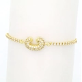 Close-up of 18k gold plated tennis bracelet with sparkling zircon horseshoe charm - Letter C