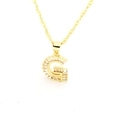 Vue macro du pendentif lettre G doré avec oxydes de zirconium et chaîne singapour - Lettre G