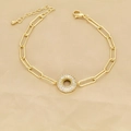 Detailed view of golden paperclip chain bracelet with zircon-encrusted round charm - Letter O