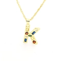 Detail view of gold-plated K-letter pendant with colorful cubic zirconia on wave chain - Letter K