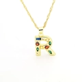 Macro shot of gold-plated letter R pendant with colorful cubic zirconia and water wave chain - Letter R