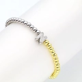 Detailed macro of a beaded bracelet featuring gold and silver beads with a zircon letter N charm - Letter N