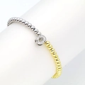 Macro shot of two-tone beaded bracelet with crystal-pave circular letter charm - Letter O