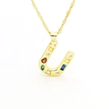 Detail of a golden horseshoe pendant necklace with colorful multi-colored gemstones - Letter U