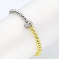 Macro view of 18k gold and silver beads bracelet with sparkling zircon letter S charm - S