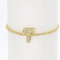 Close-up of golden 18k tennis bracelet with sparkling zircon letter T pendant - Letter T