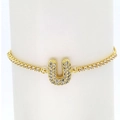 Detail of 18k gold plated tennis bracelet featuring a sparkling zircon pavé letter U charm - Letter U