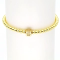 Detailaufnahme eines goldfarbenen Perlenarmbandes mit einem Zirkonia-Buchstabenwürfel E - Buchstabe E
