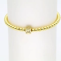 Makroaufnahme von 18k Goldperlenarmband mit mikrobesetztem Zirkonia-Buchstaben M-Würfel - M