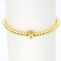 Detail eines 18k Goldperlenarmbands mit mikrobesetztem Zirkonia-Würfel und Buchstabe R - Buchstabe R