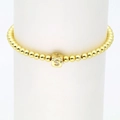 Detailaufnahme des goldenen Perlenarmbands mit einem S-Buchstabenanhänger und Zirkonia - S