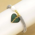 Détail macro du bracelet perlé élastique avec pendentif cœur en zircon vert et perle - Vert