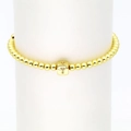 Detail eines 18k Gold Würfelarmbandes mit Kristall-T-Buchstabenanhänger und Goldperlen - Buchstabe T