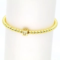 Makroaufnahme des 18k Goldperlen-Armbands mit einem quadratischen Buchstaben-U-Zirkonia - Buchstabe U