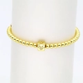 Detailaufnahme eines goldenen Perlenarmbands mit glitzerndem V-Buchstabenwürfel-Anhänger - Buchstabe V