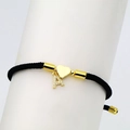 Detail of black woven cord bracelet featuring gold heart charm and micro-pave letter A charm - Letter A