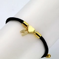Detail of black woven bracelet with golden heart and zircon letter H on display - Letter H