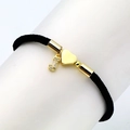 Detail of black woven bracelet featuring gold heart charm and micro-pave zircon letter J - Letter J