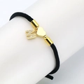 Detail of black woven rope bracelet with gold heart charm and zircon letter M pendant - M