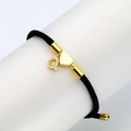 Close-up of black braided cord bracelet with gold heart charm and zircon letter Q - Letter Q