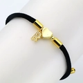 Detailed macro view of black cord bracelet with gold heart charm and zircon letter R - Letter R