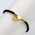 Macro detail of black braided bracelet featuring a gold letter W and heart charm - Letter W