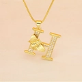 Macro detail of gold letter H pendant with micro-pave zircons and a small golden bee - Letter H