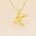 Macro detail of gold letter K pendant with micro-pave diamonds and 3D carved bee - Letter K