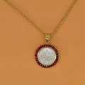 Macro view of gold portrait pendant with white shell center and red zircon stones - Rose Red