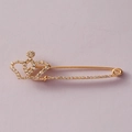 Elegante spilla a balia a forma di corona dorata con strass su sfondo viola pastello - Oro