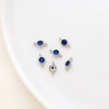 Makro-Detail von runden blauen Zirkon-Verbindern mit Versilberung für DIY-Schmuck - Saphirblau
