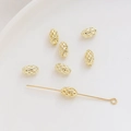 Detalle macro de cuentas ovales de malla hueca bañadas en oro 14K para accesorios de joyería - Óvalo hueco / 5x8mm (1 Pieza) / Oro de 14K