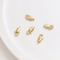 Close-up of five 14K gold-plated lobster clasps on a white ceramic plate for DIY jewelry - 10mm / 14K Gold