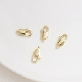 Gros plan de quatre fermoirs mousquetons plaqués or 14K pour la création de bijoux - 12mm / Or 14K