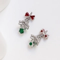 Macro shot of silver Christmas bell pendants with red bows and green zircon stones - Colored Zirconia / White Gold