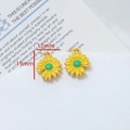 Dettaglio dei ciondoli a girasole con petali in smalto giallo e centri verdi vivaci - Stile Girasole (Prezzo Singolo 8#)