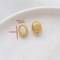 Vista macro detallada de pendientes ovalados de 12mm x 10mm con opale blanco y acabado dorado - Abalorio Ovalado Patrón Opalo (Estilo 5)