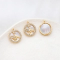 Detail of gold-plated Capricorn zodiac pendants with white mother of pearl and zircon stones - Capricorn