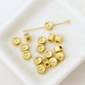 Macro shot of gold-plated flower spacer beads with textured petals in a white tray - Hollow Flower Bead (8#)